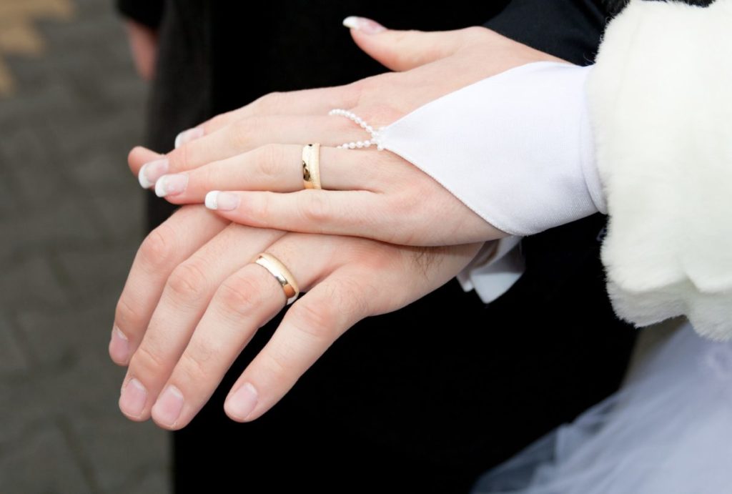 Newly married couple showing off their wedding rings