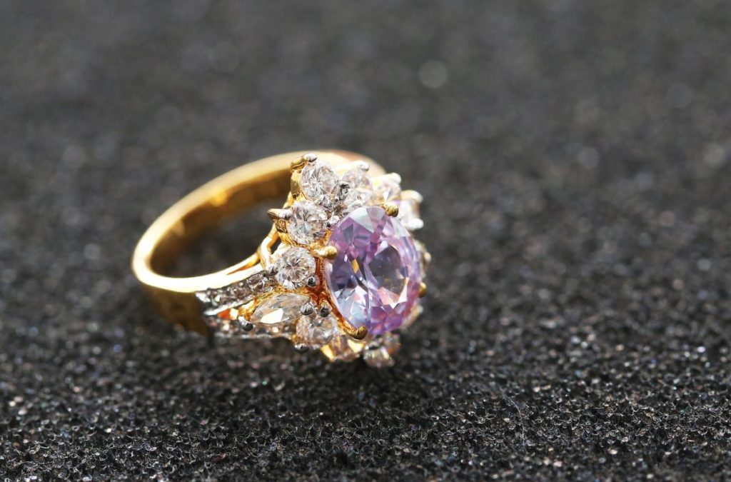 Pink gemstone on a gold diamond ring