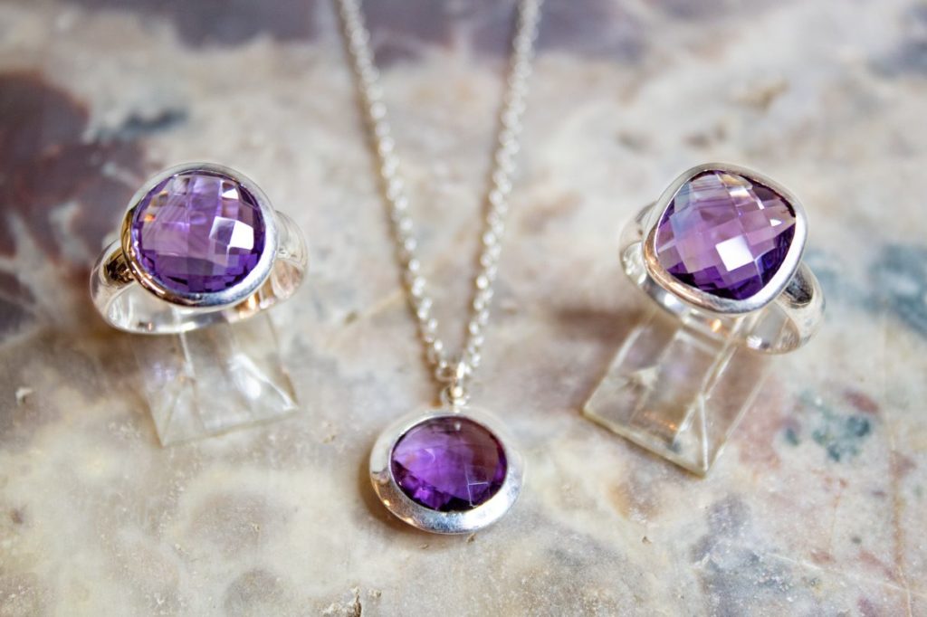Silver and purple gemstone rings and pendant