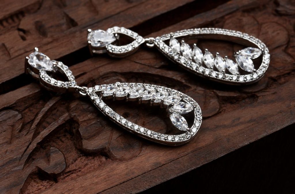 Dangly diamond earrings on a wooden background
