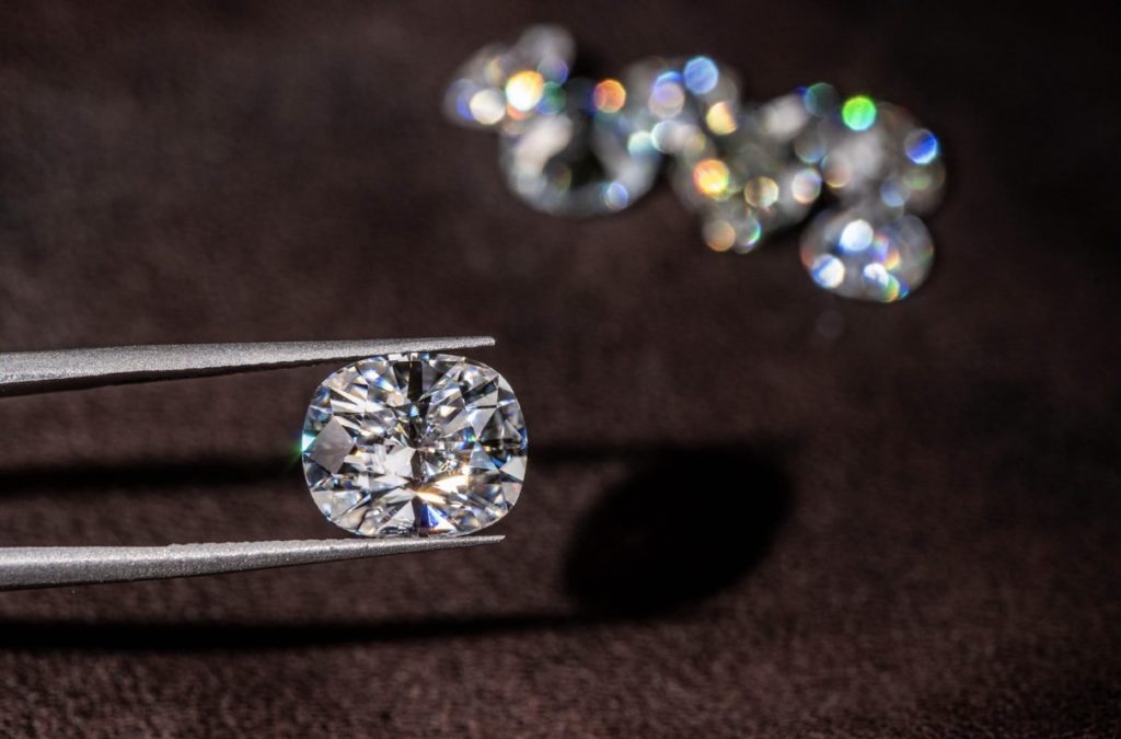 tweezers holding an oval cut diamond