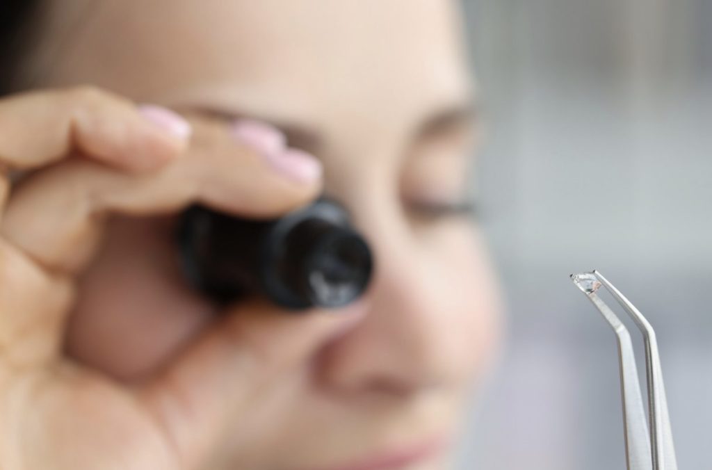 Jeweller examining a small diamond through a magnifying glass.